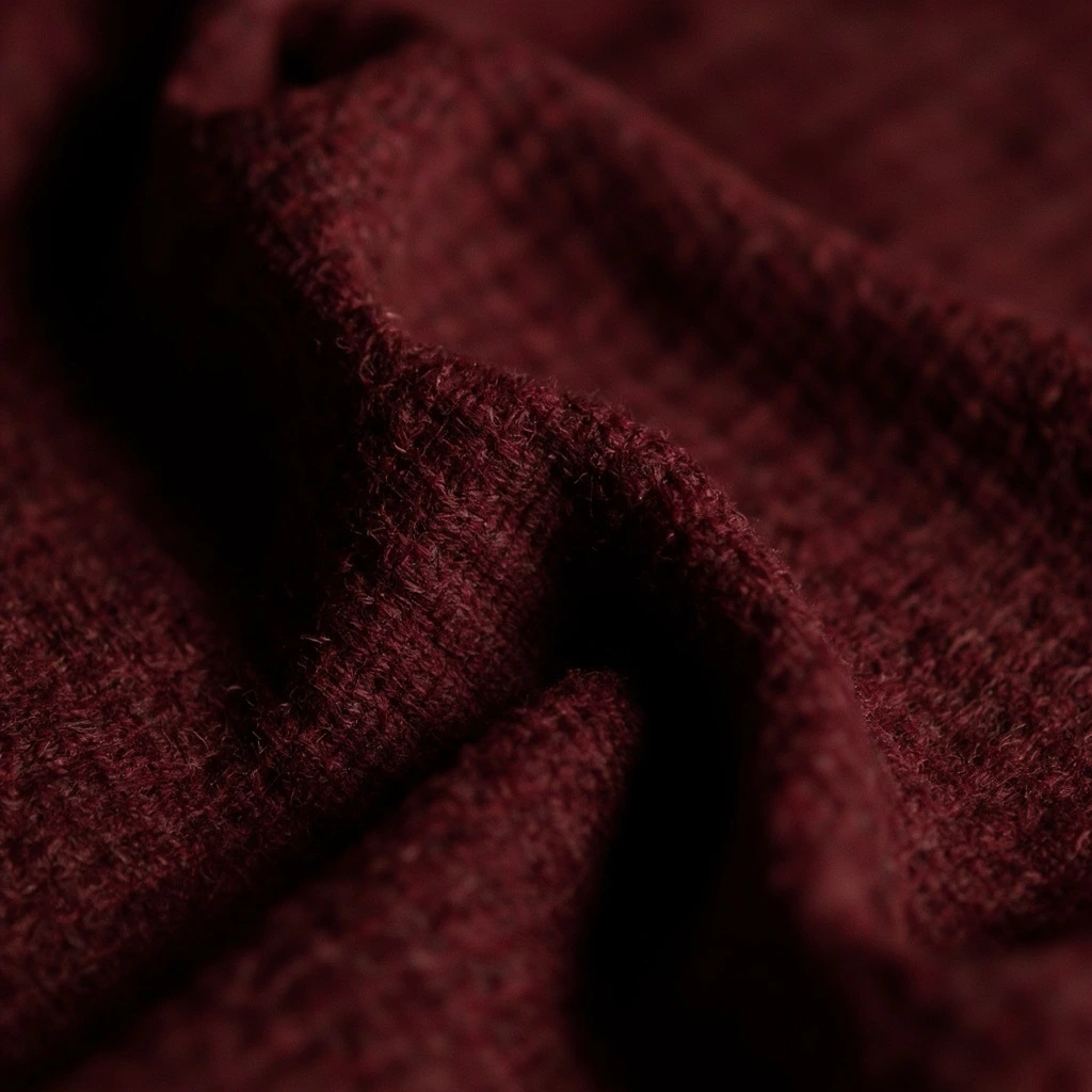 Macro close-up of oxblood wool melton showing the dense felted weave.
